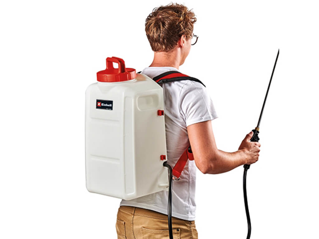 A man carries the Einhell cordless pressure sprayer on his back like a garden sprayer.