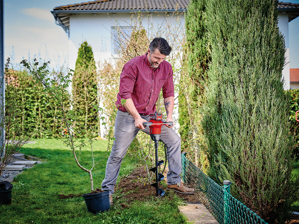 a man drills a hole with an auger