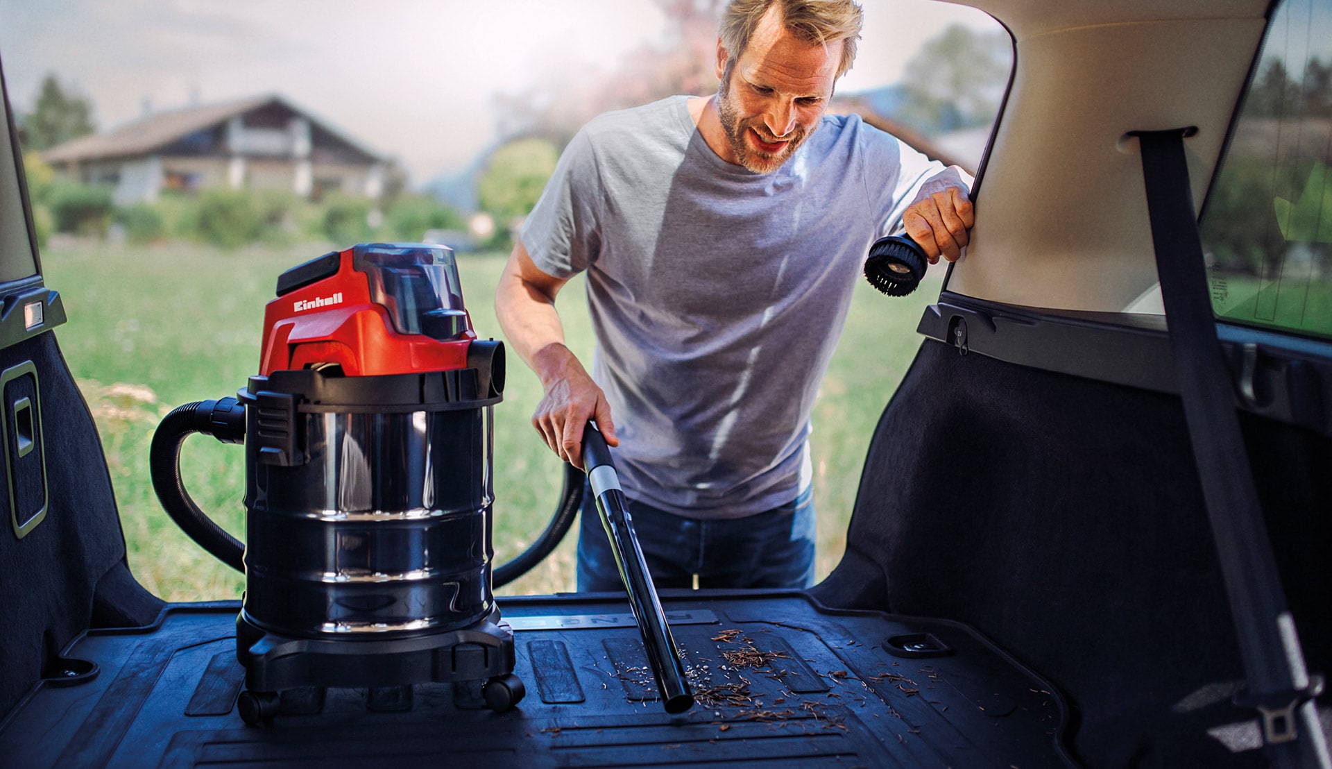 a man vacuums his trunk