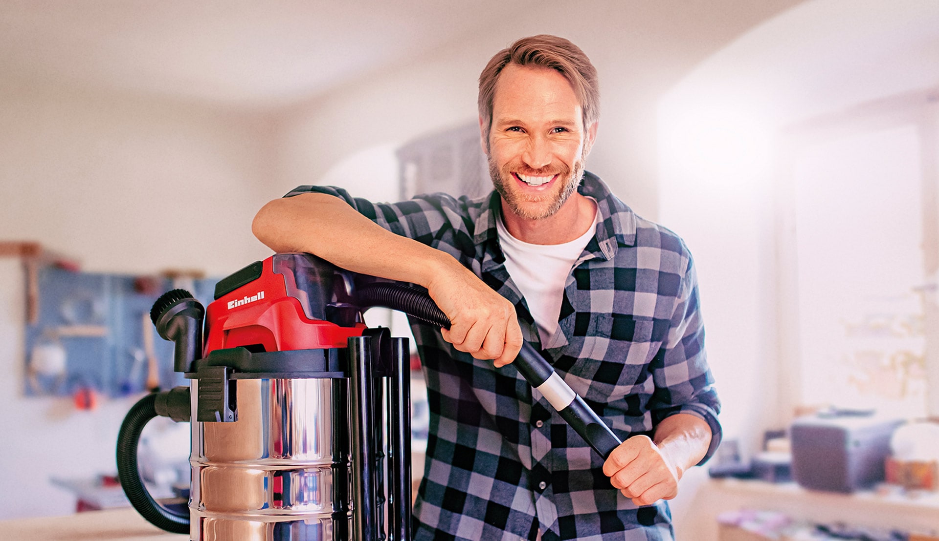 A man leans on a vacuum cleaner