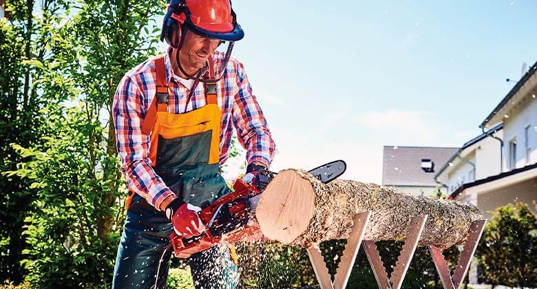 man cuts a log with a chainsaw